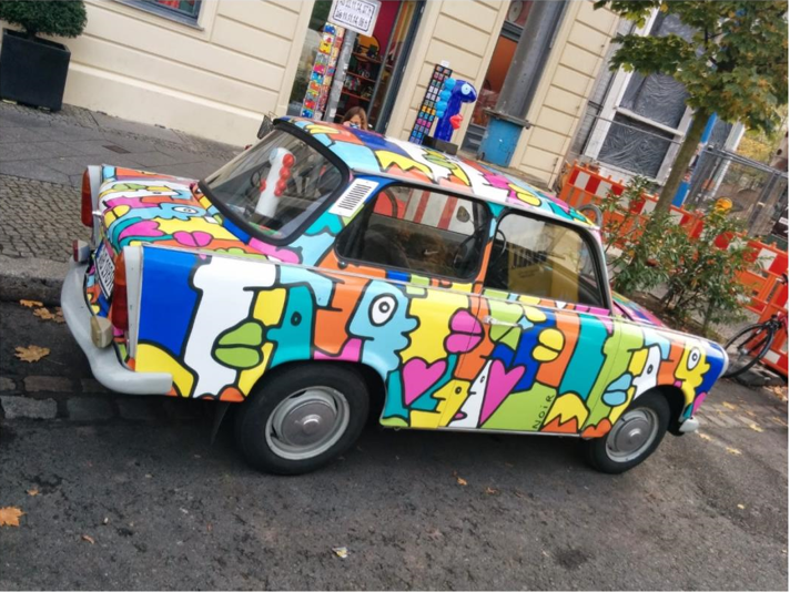 En bil av det östtyska bilmäkret Trabant som fått en visuell uppdatering, en kompetens som tillförts utifrån. Bild på en blommig bil av typen Trabant